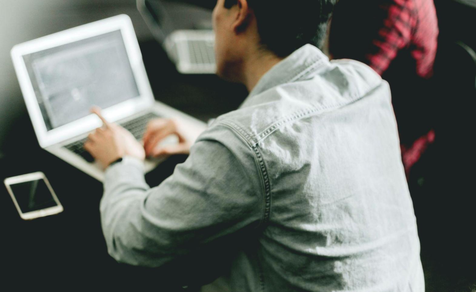 Personne consultant ses finances sur tablette avec café